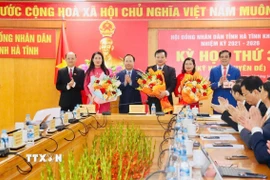 Tặng hoa chúc mừng các đồng chí được bầu vào chức danh lãnh đạo mới của Hội đồng Nhân dân và Ủy ban Nhân dân tỉnh. (Ảnh: TTXVN phát)
