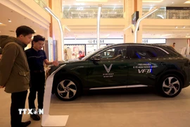 Nhân viên giới thiệu mẫu xe ôtô điện tại một cửa hàng tại Hà Nội. (Ảnh: Tuấn Anh/TTXVN)