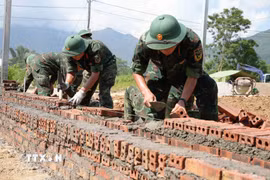 Các chiến sỹ Bộ chỉ huy Quân sự tỉnh Lai Châu tập trung xây nhà cho người dân vùng lũ Mường Than. (Ảnh: Nguyễn Oanh/TTXVN)