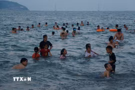 Du khách thích thú vui chơi, tắm biển dưới làn nước trong xanh của biển Cửa Lò. (Ảnh: Bích Huệ/TTXVN)