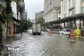 Nước ngập đến quá nửa bánh xe trên phố Mạc Thị Bưởi khiến các phương tiện lưu thông khó khăn. (Ảnh: Trần Việt/TTXVN)