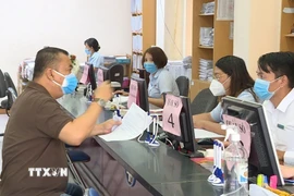 Người dân đến làm thủ tục hành chính tại bộ phận một cửa phường Hiệp Thành (Quận 12, Thành phố Hồ Chí Minh). (Ảnh: TTXVN phát)