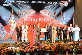 Đại sứ Việt Nam tại Đức Vũ Quang Minh trao Bằng khen của Chủ tịch Ủy ban Nhân dân thành phố Hải Phòng tặng Hội người Hải Phòng tại Đức. (Ảnh: Thanh Tùng/TTXVN)