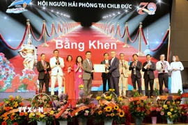 Đại sứ Việt Nam tại Đức Vũ Quang Minh trao Bằng khen của Chủ tịch Ủy ban Nhân dân thành phố Hải Phòng tặng Hội người Hải Phòng tại Đức. (Ảnh: Thanh Tùng/TTXVN)