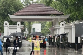 Lực lượng cảnh sát giao thông làm nhiệm vụ điều tiết giao thông trước cửa nhà tang lễ. (Ảnh: Quốc Lũy/TTXVN)