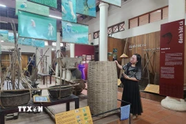 Du khách tham quan nhà trưng bày nông cụ thuộc Điểm du lịch giảm nhựa Cầu ngói Thanh Toàn. (Ảnh: Mai Trang/TTXVN)