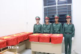 Các chiến sỹ chuẩn bị đưa mẫu hài cốt đi giám định ADN. (Ảnh: Ngọc Thiện/TTXVN)
