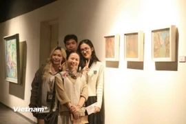 Bạn Võ Đình Lân và Vũ Yến Nhi, Ban Tổ chức triển lãm “Nữ Thời” chụp ảnh cùng 2 họa sỹ. (Nguồn: Vietnam+)