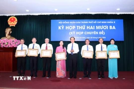 Ông Nguyễn Văn Nên, Ủy viên Bộ Chính trị, Bí thư Thành ủy Thành phố Hồ Chí Minh trao Bằng khen của Ủy ban Nhân dân Thành phố cho các cá nhân có thành tích xuất sắc cho Hội đồng Nhân dân Thành phố giai đoạn 2021-2025. (Ảnh: Xuân Khu/TTXVN)