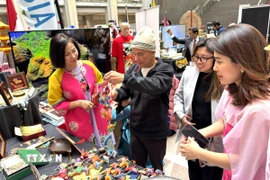 Khách tham quan tìm hiểu về sản phẩm thủ công mỹ nghệ của Việt Nam. (Ảnh: Ngọc Quang/TTXVN)