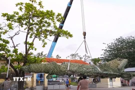 Chiếc máy bay tiêm kích MiG-21 được di dời thành công từ vị trí cũ tại đường Nguyễn Trãi, phường An Xuyên, về trụ sở Bộ Chỉ huy Quân sự tỉnh Cà Mau, đường 3/2, phường Tân Thành. (Ảnh: Huỳnh Anh/TTXVN)