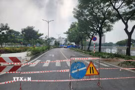 Lực lượng chức năng phong tỏa hiện trường vụ sụt lún trên đường Ba Đình. (Ảnh: Tiến Lực/TTXVN)