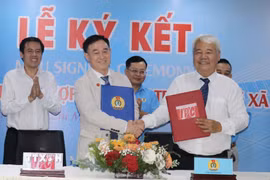 Ông Võ Khắc Thái (trái), Phó Chủ tịch Thường trực Liên đoàn Lao động Thành phố Hồ Chí Minh cùng ông Võ Hồng Tài, Quyền Tổng Giám đốc Công ty IPC (phải) thực hiện nghi thức ký kết hợp tác xây nhà ở xã hội. (Ảnh: Thanh Vũ/TTXVN)