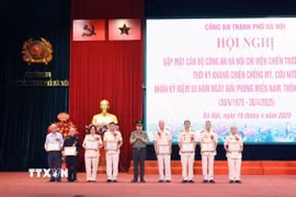 Thiếu tướng Nguyễn Thanh Tùng, Giám đốc Công an thành phố Hà Nội trao Giấy khen cho các đồng chí có nhiều đóng góp trong hoạt động của Ban liên lạc chiến trường B,C,K. (Ảnh: Phạm Kiên/TTXVN)
