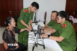 Phòng Cảnh sát Quản lý Hành chính về trật tự xã hội (PC06) Công an Thành phố Hồ Chí Minh thực hiện các thủ tục thu mẫu thu mẫu AND. (Ảnh: Thanh Vũ/TTXVN)
