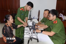 Phòng Cảnh sát Quản lý Hành chính về trật tự xã hội (PC06) Công an Thành phố Hồ Chí Minh thực hiện các thủ tục thu mẫu thu mẫu AND. (Ảnh: Thanh Vũ/TTXVN)
