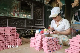 Trang trí tượng Tam vị Táo quân phù hợp thị hiếu khách hàng dịp Tết. (Ảnh: Võ Văn Dũng/TTXVN)