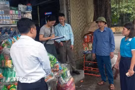 Ông Nguyễn Văn Chuẩn tham gia tuyên truyền vận động các hộ kinh doanh không lấn chiếm hành lang an toàn giao thông. (Ảnh: Nguyễn Chinh/TTXVN)
