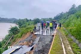Theo ghi nhận tại hiện trường, toàn bộ phần mặt đường dài khoảng 30 mét đã bị đứt gãy, sạt trượt hoàn toàn xuống phía ta luy âm, giáp bờ sông Hồng. (Ảnh: TTXVN phát)