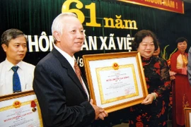 Phó Chủ tịch nước Trương Mỹ Hoa trao Huân chương Lao động hạng Nhì tặng Phó Tổng Giám đốc TTXVN Nguyễn Duy Cương nhân dịp kỷ niệm 61 năm Ngày truyền thống TTXVN, tháng 9/2006. (Nguồn: TTXVN)