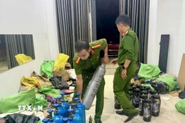 Lực lượng chức năng thu giữ các bình "khí cười". (Ảnh: TTXVN phát)