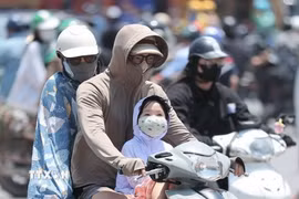 Người dân khi ra đường cần trang bị khăn, mũ, áo chống nắng. (Ảnh: Minh Quyết/TTXVN)