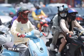 Người dân khi ra đường cần trang bị khăn, mũ, áo chống nắng. (Ảnh: Minh Quyết/TTXVN)