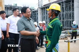 Thủ tướng Phạm Minh Chính với công nhân thi công dự án Cảng Hàng không Quốc tế Phú Quốc. (Ảnh: Dương Giang/TTXVN)