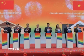 Lãnh đạo tỉnh Cao Bằng, lãnh đạo huyện Hạ Lang cùng đại diện lãnh đạo huyện Đại Tân (Trung Quốc) bấm nút khởi động cửa khẩu song phương Lý Vạn-Thạc Long. (Ảnh: Văn Đạt/TTXVN)