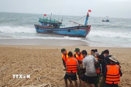 Lực lượng chức năng và người dân địa phương hỗ trợ cứu nạn tàu cá BĐ 97820 TS. (Ảnh: TTXVN phát)