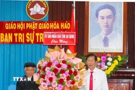 Phó Chủ tịch Ủy ban Nhân dân tỉnh An Giang Lê Văn Phước (phải) tặng hoa mừng Ban Trị sự Trung ương Giáo hội Phật giáo Hòa Hảo. (Ảnh: Công Mạo/TTXVN)