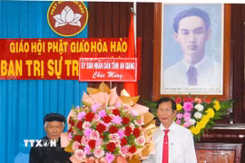 Phó Chủ tịch Ủy ban Nhân dân tỉnh An Giang Lê Văn Phước (phải) tặng hoa mừng Ban Trị sự Trung ương Giáo hội Phật giáo Hòa Hảo. (Ảnh: Công Mạo/TTXVN)