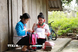 Phụ nữ dân tộc Mảng may những bộ trang phục truyền thống. (Ảnh: Quý Trung/TTXVN)