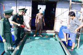 Lực lượng Biên phòng kiểm tra số dầu chờ trên tàu. (Ảnh: TTXVN phát)