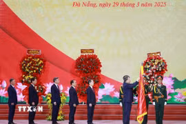 Tổng Bí thư Tô Lâm gắn Huân chương Lao động hạng Nhất lên Cờ truyền thống của Thành phố Đà Nẵng. (Ảnh: Thống Nhất/TTXVN)