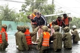Công an dùng canô ứng cứu người dân phường Tuy Hoà bị ngập lũ. (Ảnh: Tường Quân /TTXVN)