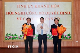 Ông Nghiêm Xuân Thành, Bí thư Tỉnh ủy Khánh Hòa trao quyết định và tặng hoa chúc mừng Chủ tịch và Phó Chủ tịch Hội đồng Nhân dân tỉnh. (Ảnh: Công Thử/TTXVN)