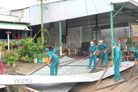 Lực lượng chức năng xã An Phú (An Giang) hỗ trợ người dân trên địa bàn khắc phục thiệt hại do mưa lớn kèm dông lốc xảy ra trên địa bàn vào tối 11/9/2025. (Ảnh: Công Mạo/TTXVN)