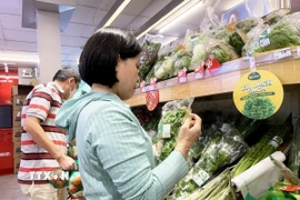 Khách chọn mua sản phẩm “xanh” và “sạch” thân thiện môi trường tại siêu thị WinMart+. (Ảnh: Hồng Đạt/ TTXVN)