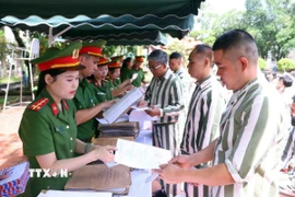 Cán bộ trại giam Phú Sơn 4 (Bộ Công an) trao giấy chứng nhận đặc xá cho người được đặc xá (đợt 2) năm 2025. (Ảnh: Phạm Kiên/TTXVN)