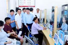 Đoàn công tác tiếp xúc công dân làm thủ tục hành chính tại Trung tâm Phục vụ hành chính công xã Đạo Trù. (Ảnh: PV/TTXVN)