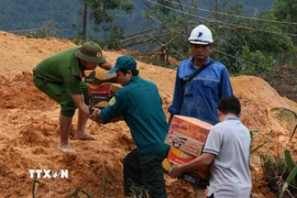 Tuyến Quốc lộ 40B bị sạt lở nặng, tuyến đường nối từ vùng đồng bằng về nhiều khu vực miền núi bị đình trệ hoàn toàn, hàng hóa tiếp tục được vận chuyển bằng sức người. (Ảnh: Đoàn Hữu Trung/TTXVN)