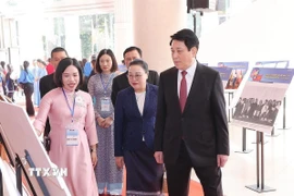 Chủ tịch nước Lương Cường tham quan trưng bày ảnh về quan hệ hữu nghị đặc biệt Việt Nam-Lào. (Ảnh: Lâm Khánh/TTXVN)
