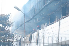 Các lực lượng có mặt ở hiện trường để chữa cháy, cứu hộ cứu nạn. (Ảnh: Lê Đông/TTXVN)