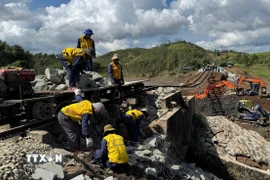 Các công nhân gia cố phần móng đường sắt bị sạt lở do bão số 13 ở xã Xuân Lãnh (tỉnh Đắk Lắk) . (Ảnh: Tường Quân/TTXVN)
