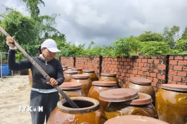 Chị Trương Thị Bốn (Chủ cơ sở Nước mắm Cửa Khe Bốn Thái) cho biết mắm phải ủ trên 12 tháng thì mới đậm vị, thơm ngon. (Ảnh: Quốc Dũng/TTXVN)