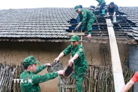 Lực lượng Đồn Biên phòng Tùng Vài (Tuyên Quang) giúp người dân lợp lại mái nhà cho người dân bị ảnh hưởng của mưa đá, dông lốc. (Ảnh: Đức Thọ/TTXVN)