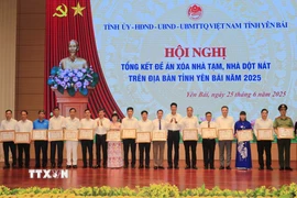 Phó Chủ tịch Thường trực Ủy ban Nhân dân tỉnh Yên Bái Nguyễn Thế Phước tặng Bằng khen cho các tập thể có thành tích trong phong trào xóa nhà tạm, nhà dột nát. (Ảnh: Tiến Khánh/TTXVN)