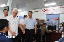 Bí thư Tỉnh ủy Bình Dương Nguyễn Văn Lợi kiểm tra giải quyết thủ tục hành chính tại bộ phận một cửa. (Ảnh: Văn Hướng/TTXVN)