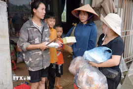 Tiếp tế thực phẩm cho những gia đình bị lũ cuốn trôi. (Ảnh: Nguyễn Oanh/TTXVN)